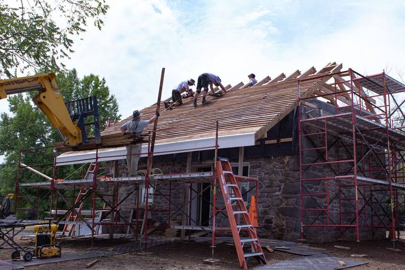 Local roofing crew installing new wood shingles across a full roof replacement
