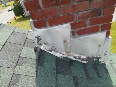 Close-up of worn chimney flashing on a roof in need of repair